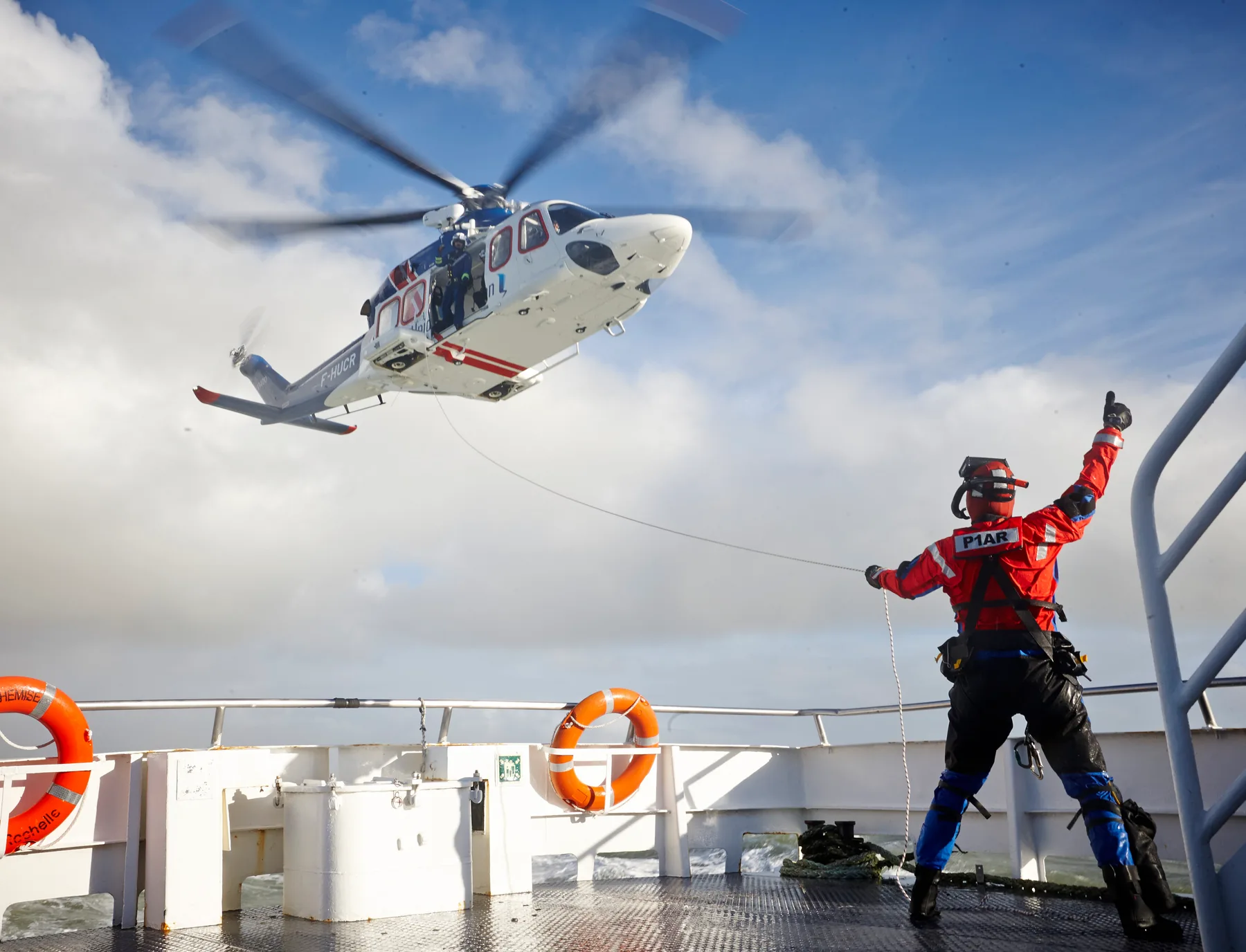 Vessel hoist operations with crew directing an AW139 helicopter
